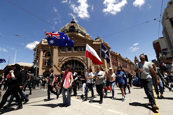 Protestors march down Flinders Street outside Flinders Street Station on November 27, 2021 in Melbourne, Australia. 