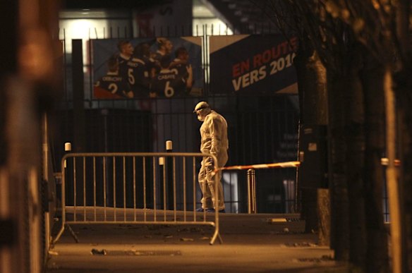 An investigating police officer works outside the Stade de France stadium after an explosion.