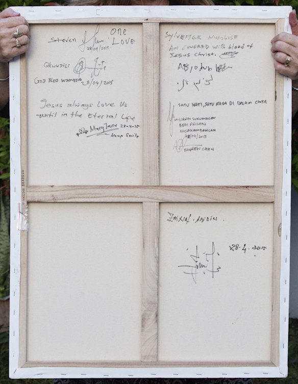 On the back of the paiting of an Indonesian flag dripping with blood are the signatures and fingerprints in red paint off the nine prisoners awaiting execution.