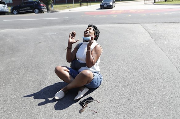 Ceci Munoz sits in the street as she cries and reacts at Yates High School, in Houston, after learning that former Minneapolis police Officer Derek Chauvin was convicted of murder and manslaughter in the death of George Floyd.