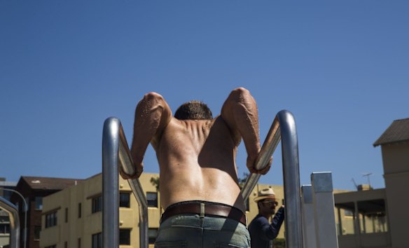 A man gets his pull ups done this morning at the outdoor gym bars at North Bondi.