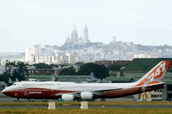 The new Boeing 747-8 Intercontinental jetliner taxis, with "le Sacre Coeur" church in the background, on the eve of the Paris Air Show.