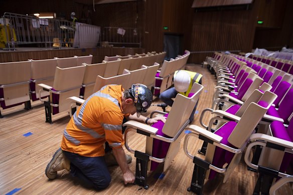 A worker installs the seating during the refurbishment.