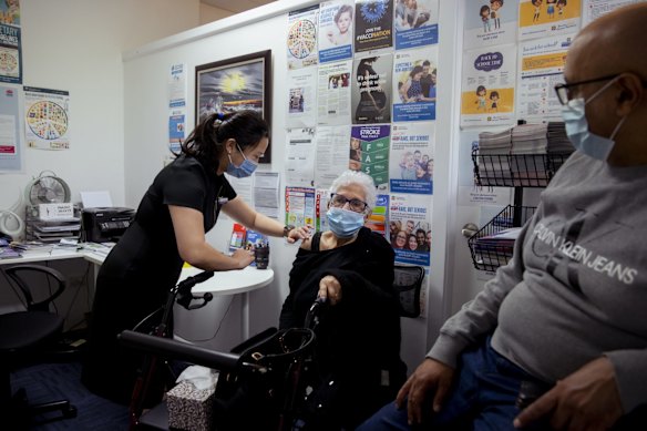 Pharmacist Veronica Nou gives Nawal Metias her first dose of the AstraZeneca COVID-19 vaccine, as her son Hany Metias watches, in St Marys.