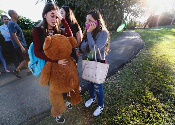 Students wait to be picked up after a shooting at Marjory Stoneman Douglas High School in Parkland, Fla.