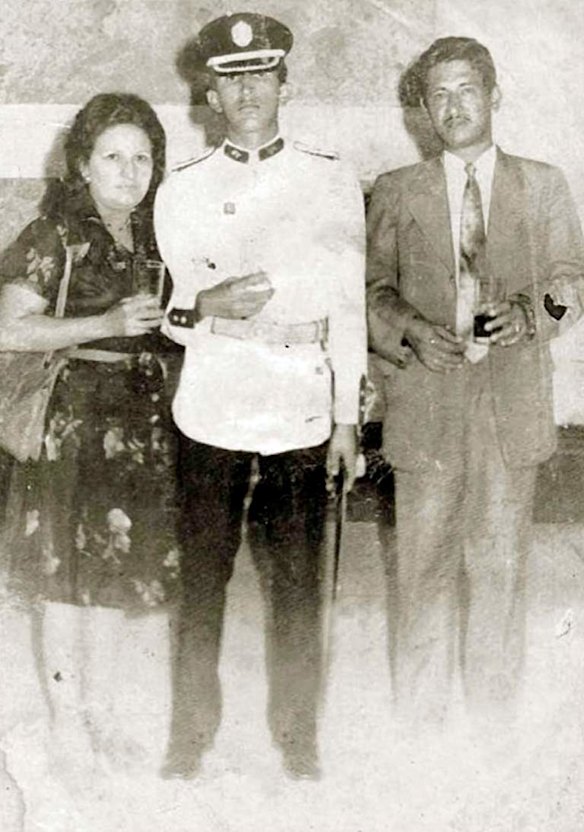 In this July 5, 1975 photo released by Miraflores Press Office, Hugo Chavez, center, poses with his mother Elena Frias and father Hugo de los Reyes Chavez at his graduation from the military academy in Caracas, Venezuela.