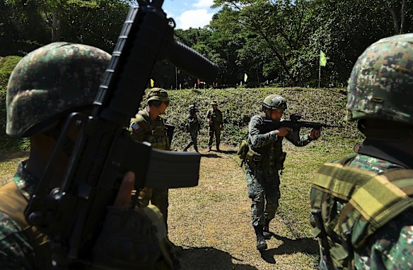 Corporal Robert Druery (2nd from left) and Private Daniel Martin (4th from left) with the 8th/9th Royal Australian Regiment and Land Mobile Training Team during training at the firing range.
