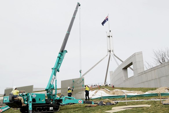 A security fence is installed across the lawns of Parliament House.