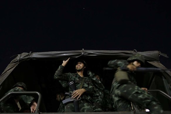 Soldiers jump off a truck as they take up position at the democracy monument in Bangkok.