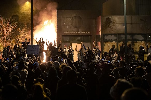 Protesters gather outside the burning Minneapolis police 3rd Precinct building.