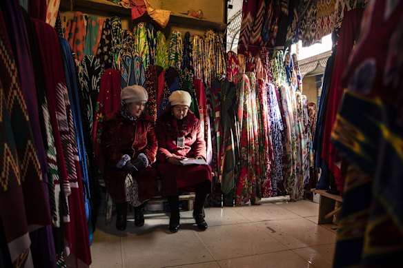 Vendors sit in a fabric stall inside the main bazaar in Kashgar, Xinjiang autonomous region, China.