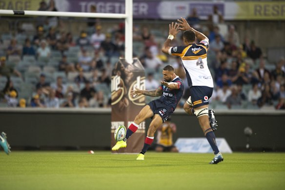 The Brumbies' Rory Arnold tries to charge down a kick from the Rebels' Quade Cooper. 