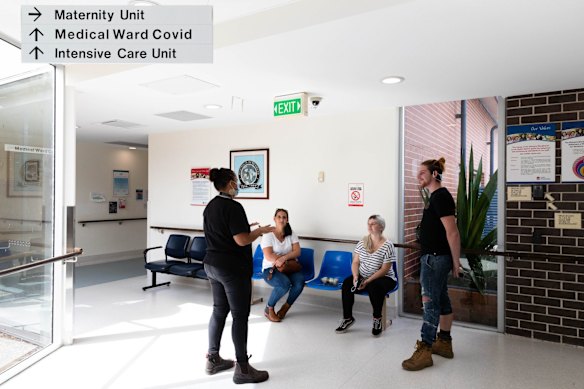 Mel Briggs, midwife at Waminda Aboriginal maternity clinic, explains some of the hospital's procedures to Ebony Tibbitts, who is 35 weeks pregnant, her partner  Drae Humphries and her mother Emma Tibbitts. 