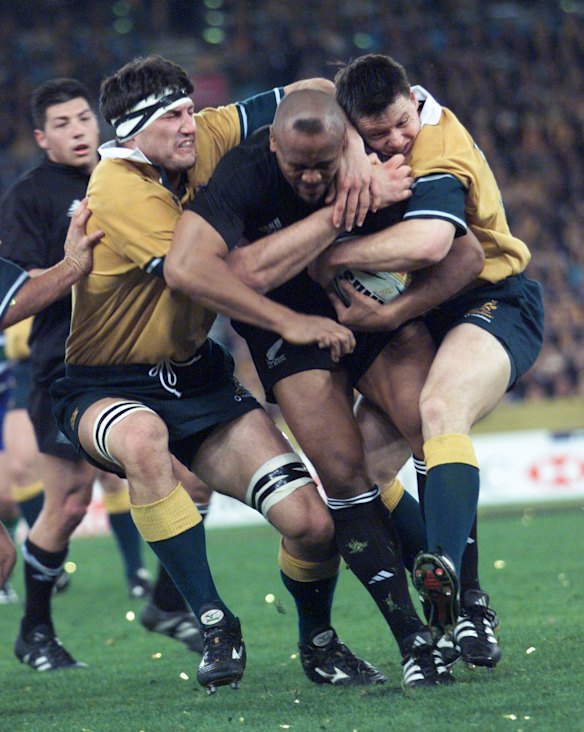 Wallabie greats John Eales and Matthew Burke try to tackle Jonah Lomu.