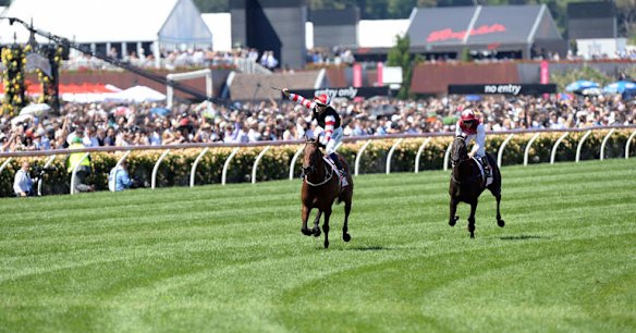 Jockey Hugh Bowman celebrates on Polanski after winning the Victoria Derby at Flemington.