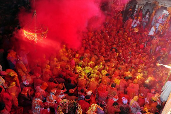 Indian Hindu devotees throw coloured powder at the Radha Rani temple in Barsana, India.
