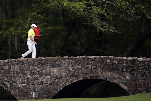 Tiger Woods, right, walks with Rory McIlroy over the Nelson Bridge.