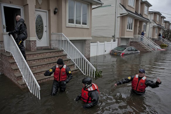 Rescue workers search for trapped residents in the Dongan Hills neighborhood of the Staten Island borough of New
