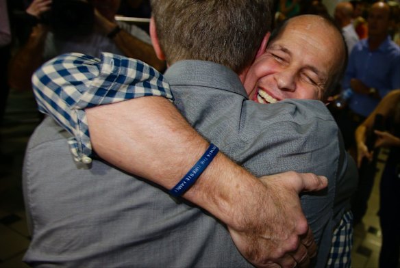 Greste embraces a friend on his arrival at Brisbane's international airport.