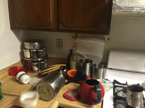 The kitchen had pots and pans strewn over it.