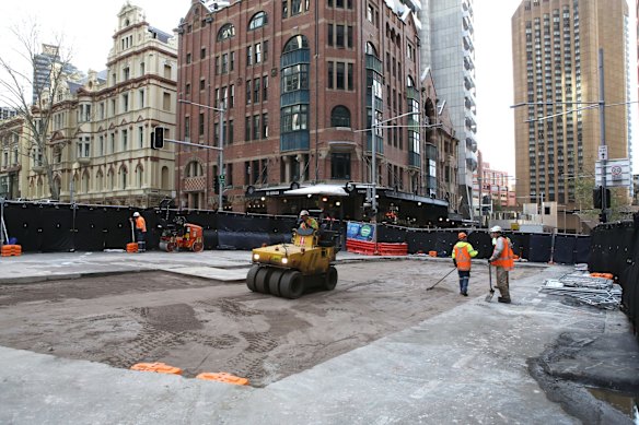 Workers prepare the road surface as progress continues on the Sydney Light Rail on the corner of Bridge and George St.