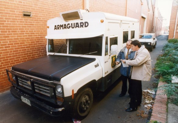 Police examine the abandoned Armaguard van after the 1994 armed robbery in Richmond.