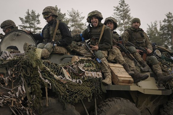 Ukrainian servicemen ride on an armored transporter driving through a Russian position overran by Ukrainian forces outside Kyiv. Heavy fighting raged on the outskirts of Kyiv and other zones Thursday amid indications the Kremlin is using talk of de-escalation as cover while regrouping and resupplying its forces and redeploying them for a stepped-up offensive in eastern Ukraine.
