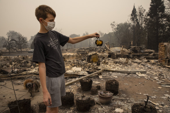 Jacen Sullivan, 14, from Talent, Oregon, holds a burned tomato he found in the garden at his burned home.