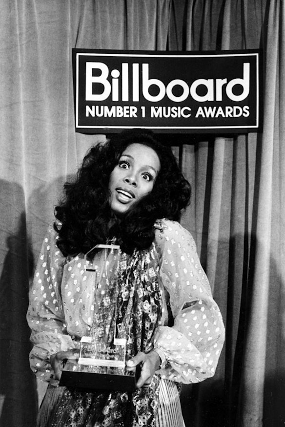 Donna Summer in 1977 holding her award at the Billboard Number 1 Music Awards.