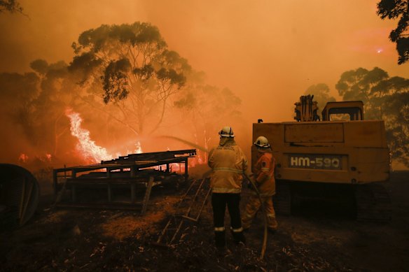 RFS firefighters working to protect properties as the North Black Range bushfire threatens properties at Bombay, NSW.