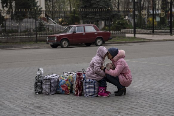 A mother hugs her daughter as they wait for a bus to flee from Sloviansk city, in Donetsk district, to travel to Rivne , western Ukraine.