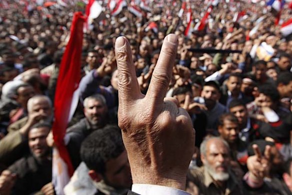Anti-government protester flashes a victory sign in Tahrir square, Cairo.