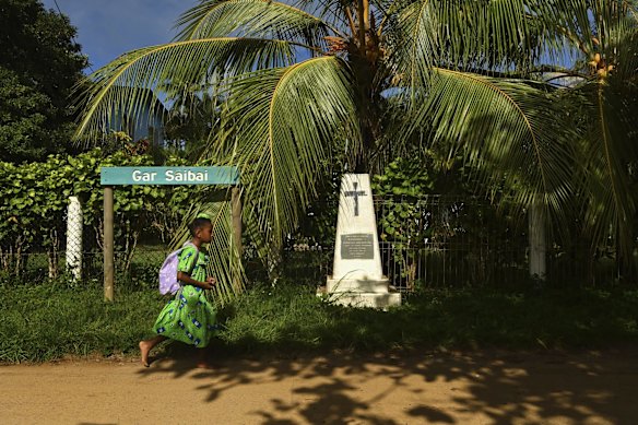 A girl walks past the remebrance statue on Saibai Island dedicated to Garami & Jawai Mamoose who brought the missionaries from Dauan Island to Saibai Island. 