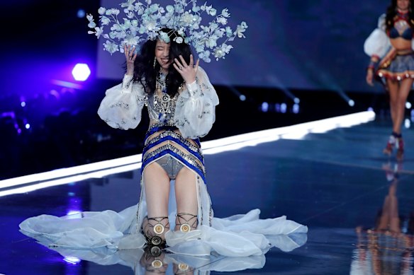 Model Ming Xi falls to her knees during the Victoria's Secret fashion show.