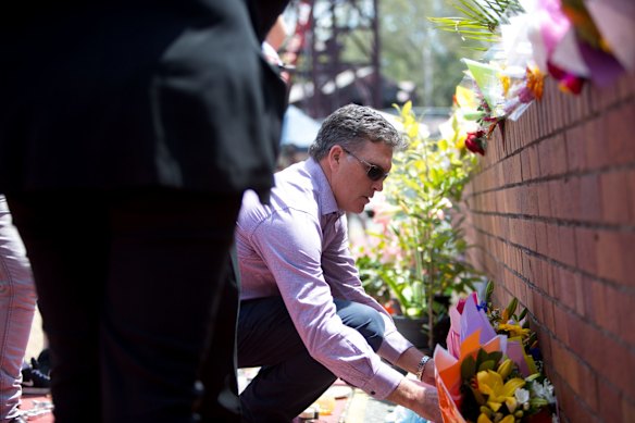 Dreamworld chief executive Craig Davidson leave flowers at the site on Friday after a private memorial service at Dreamworld.