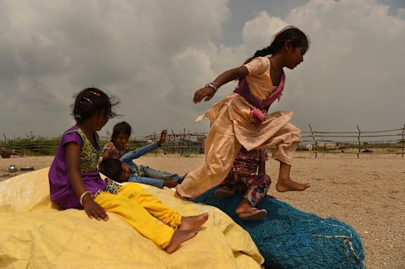 A group of children play in Tragadi Bandar, a fishing settlement on the Kutch coast, in western India. The settlement is home to over 100 families, who have been forced to change their fishing habits due to the operations of the nearby Adani power plant and port.