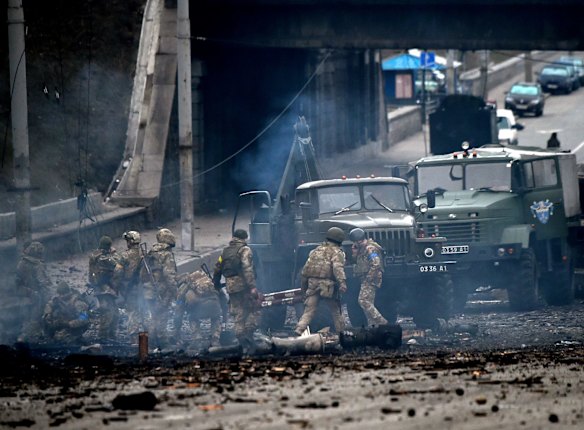 Ukrainian service members collect unexploded shells after fighting with a Russian raiding group in the capital Kyiv on Saturday morning (Ukraine time).