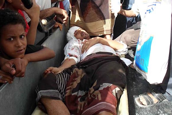 An anti-regime demonstrator gets first aid treatment after a grenade was lobbed at protesters from a speeding car in the Yemeni city of Taiz.