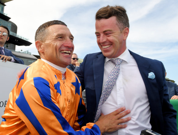 Jockey Opie Bosson and trainer Jamie Richards celebrate in the mounting yard.