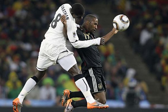 Jonathan Mensah of Ghana and Cacau of Germanf (R) jump for the ball.