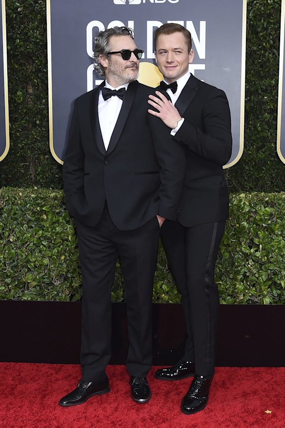 Joaquin Phoenix, left, and Taron Egerton arrive at the 77th annual Golden Globe Awards.