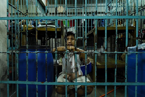 Wounded drug user Francisco Maneja 27, sits in a cell at Manila Police Headquarters. Francisco, a father of two, was shot during a drug operation and played dead in a pool of blood before sitting up in front of media crews yelling "help me, help me". 