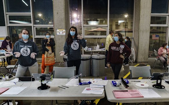 Loyola Law School students, from left, Laura Rodi, Laura Bond, and Kathy Feeney, dance "Macarena," a few minutes before closing their polling place at the Los Angeles City College in Los Angeles.