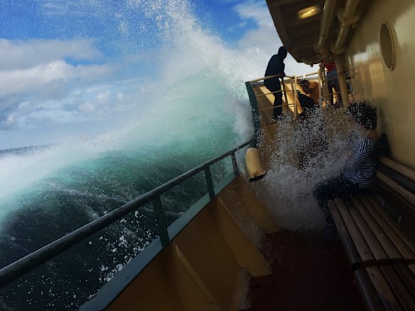 Japanese tourists are soaked by a heavy swell on the Manly Ferry in 2017.
