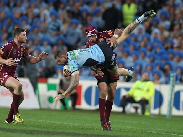 Johnathan Thurston tackles Josh Dugan.