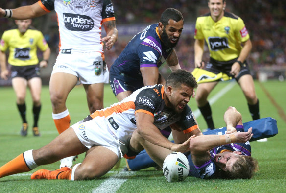 Cameron Munster of the Storm is prevented from scoring a try by Russell Packer of the Tigers.