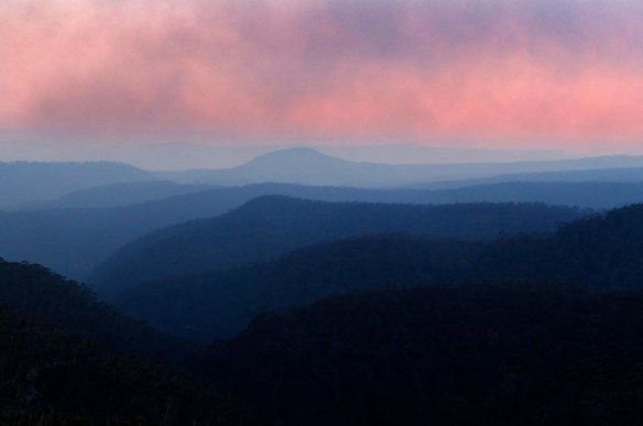 As fires continue to burn, smoke drifts across the Blue Mountains south of the Bells Line of Road west of Mt Tomah.
