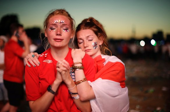 England soccer fans react after losing the semifinal match between Croatia and England at the 2018 soccer World Cup, in Hyde Park, London.