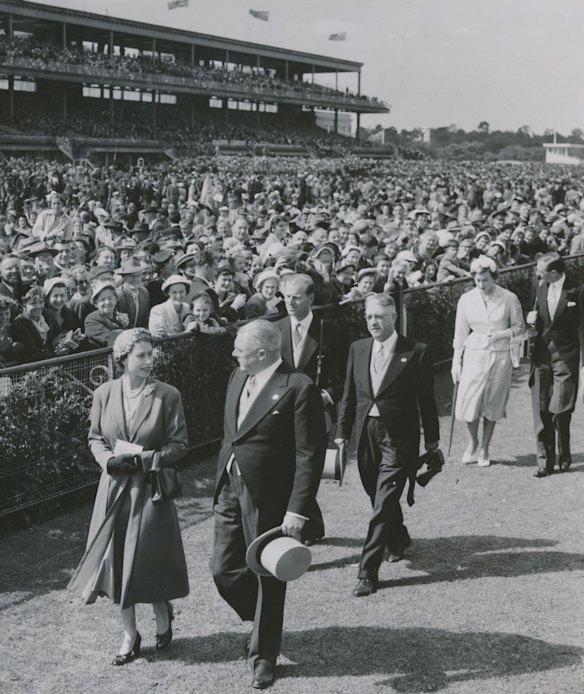 Queen Elizabeth II chats with Sir Chester Manifold, V.R.C. chairman, at Flemington Racecourse. Prince Philip, Duke of Edinburgh, follows behind. 27-02-1954. 