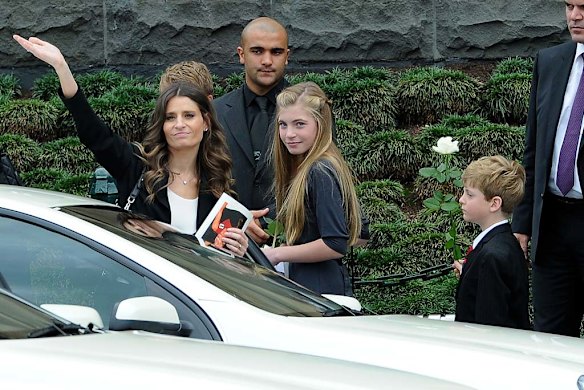 Sam Stynes with children Matisse and Tiernan waves to crowds at Federation Square after the memorial service for Jim Stynes at St Paul's Cathederal.